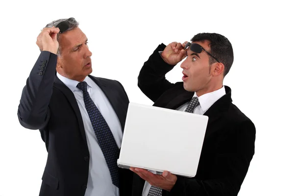 Uomini d'affari stupiti con un portatile in mano — Foto Stock