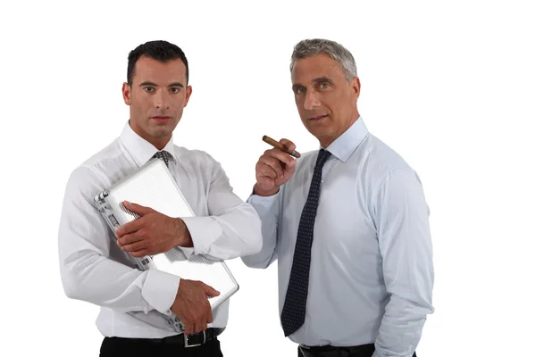 Босс держит сигару, пока работник делает всю работу. — стоковое фото