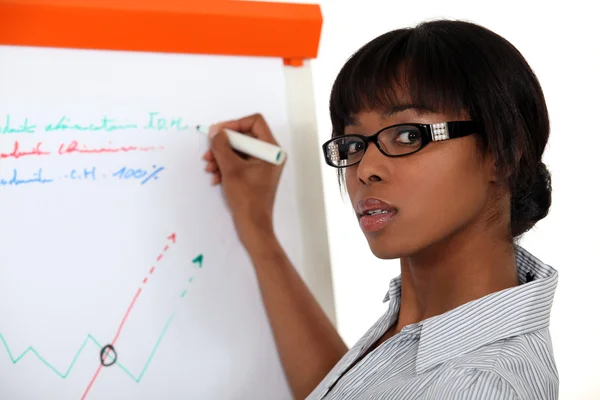 Young woman writing on a paperboard — Stock Photo, Image