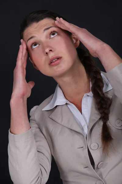 Kvinna som lider av en bultande huvudvärk Stockfoto