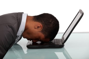 Exhausted businessman sleeping over his laptop clipart