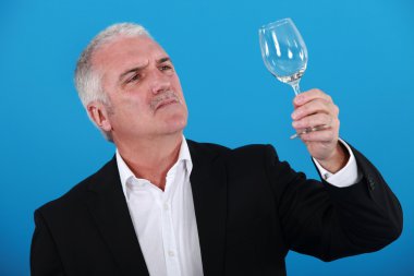 Man examining a wine glass clipart
