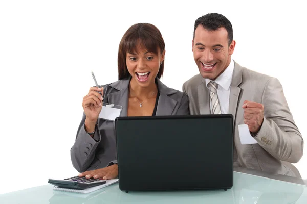 Professionnels d'affaires joyeux regardant une vidéo sur leur ordinateur portable — Photo