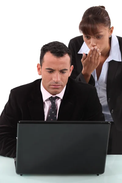 Homem e mulher surpresos na frente do laptop — Fotografia de Stock