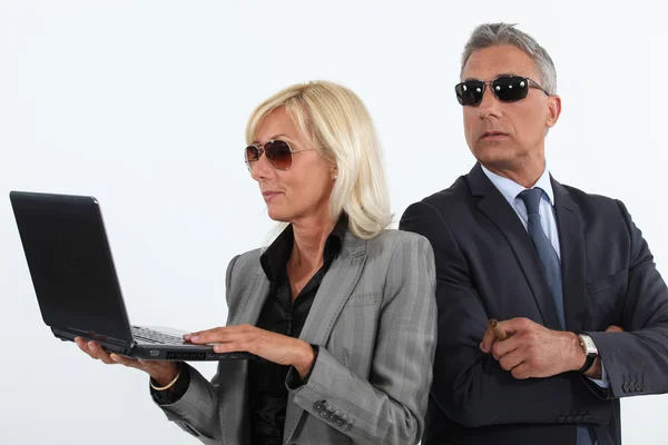 Shady mature business couple with a laptop — Stock Photo, Image