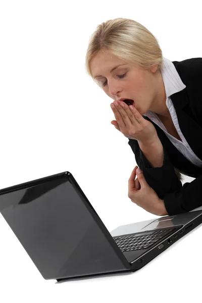 Женщина зевает перед компьютером — стоковое фото