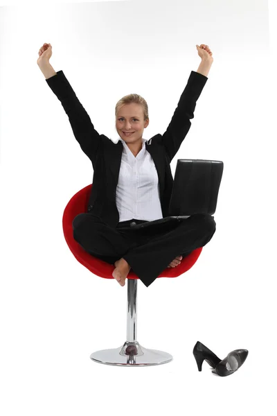 Emocionada mujer de negocios rubia sentada descalza en la silla —  Fotos de Stock