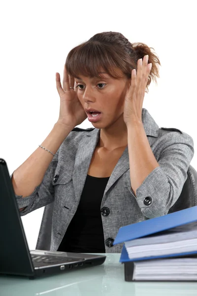 Orolig kvinna som tittar på hennes laptop — Stockfoto