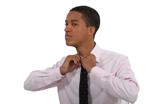 Jeune homme ajustant sa cravate — Photo