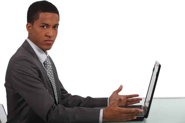 Недовольный офисный работник сидел с ноутбуком — стоковое фото