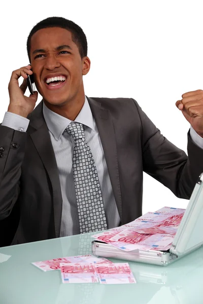 Ecstatic businessman with a briefcase full of money — Stock Photo, Image