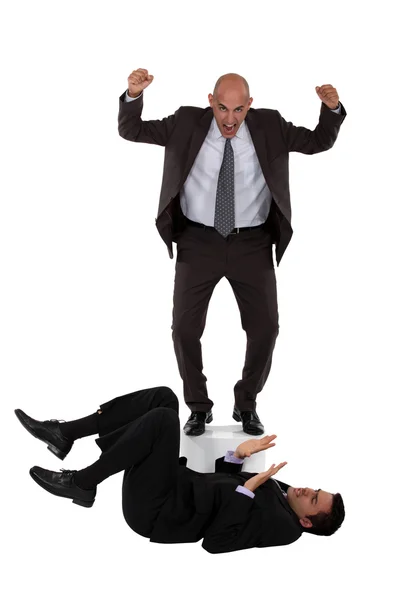 Angry boss shouting at employee laying on the floor — Stock Photo, Image