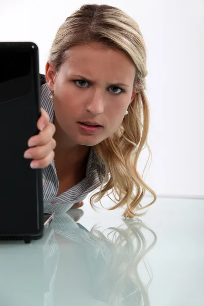 Mujer molesta espiando alrededor de su portátil — Foto de Stock