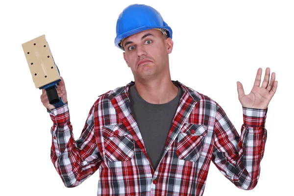 Construction worker holding up a sander — Stock Photo, Image