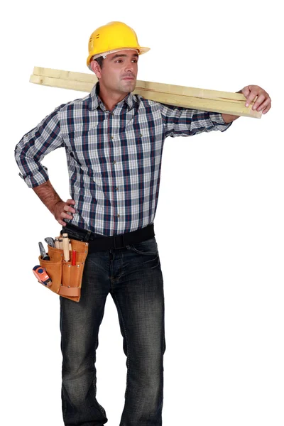 Hantverkare transporterar en planka — Stockfoto