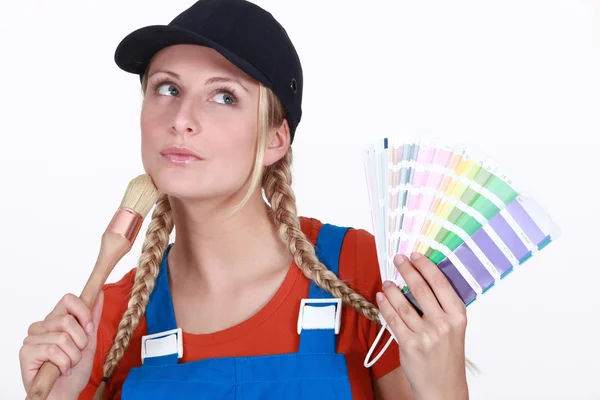 Blonde painter looking inspired holding color chart and brush — Stock Photo, Image