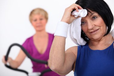 Two women sweating at the gym clipart