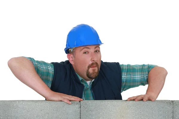 Bearded mason stood by unfinished wall — Stock Photo, Image