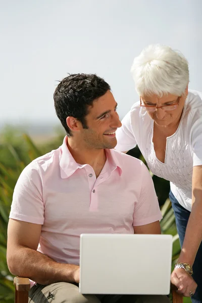 Man and senior woman with a laptop — Stock Photo, Image