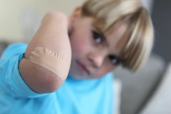 Dirseğini üzerine yara bandı ile küçük çocuk — Stok fotoğraf