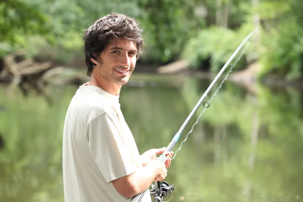 Человек рыбачит на реке — стоковое фото