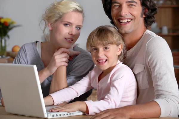 Родители инициируют маленькую девочку на компьютер — стоковое фото