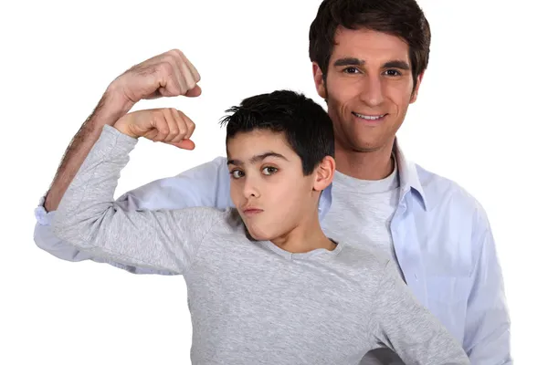 Otec a syn ukazuje svaly — Stock fotografie