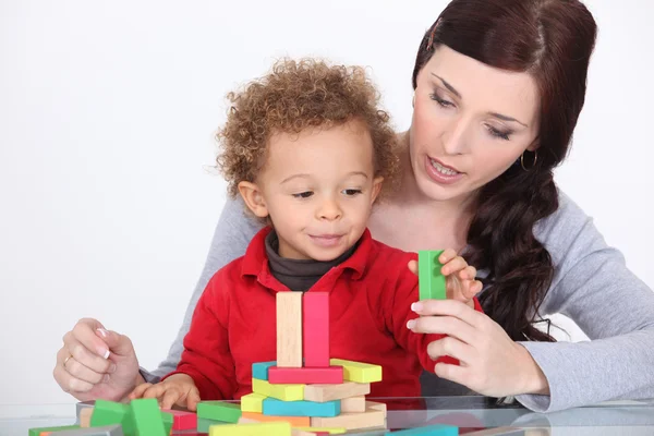 Молодая мать и маленький сын играют со строительным набором — стоковое фото