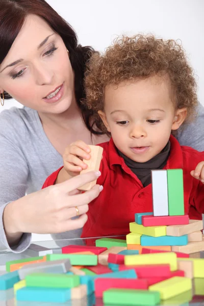 Kvinna och barn leker med träkonstruktion spel — Stockfoto