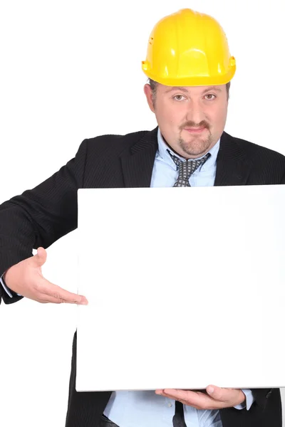 Uomo d'affari con un cappello duro con una tavola lasciata in bianco per il tuo messaggio — Foto Stock
