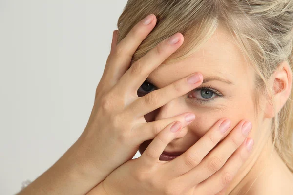 Mujer rubia con las manos en la cara — Foto de Stock