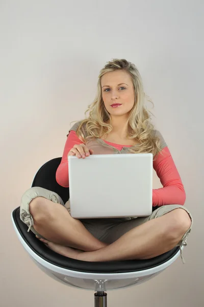 Jonge vrouw op fauteuil met laptop — Stockfoto