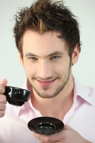Un homme souriant buvant une tasse de café — Photo