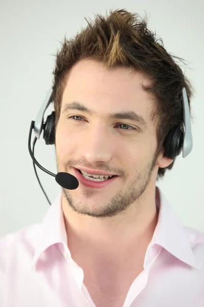 Attractive man speaking into a headset — Stock Photo, Image