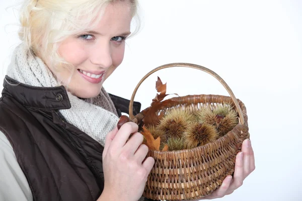 Donna con cesto di castagne — Foto Stock