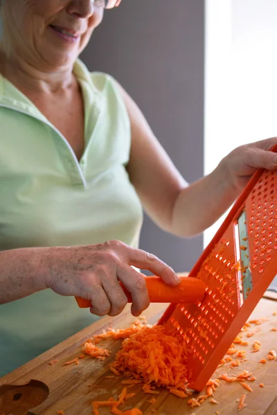 Donna che grattugia una carota — Foto Stock