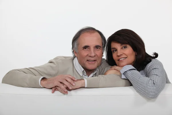 Mature couple leaning on back of sofa — Stock Photo, Image