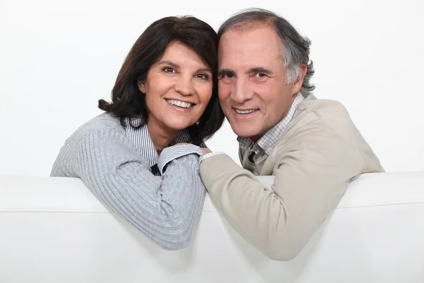 A middle age couple on their couch. — Stock Photo, Image