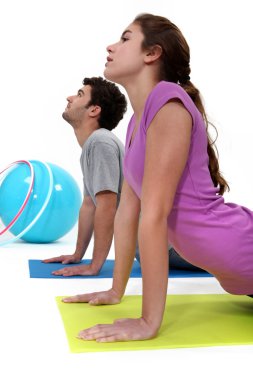 Couple doing yoga on mat clipart