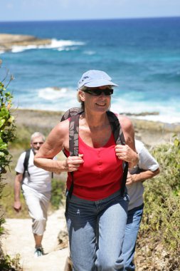 Woman hiking by the seaside clipart