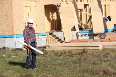 Foreman stood by unfinished wooden house clipart