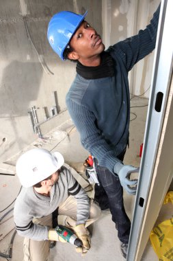 Two handymen fitting plasterboard clipart