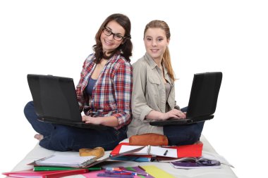 Two female students with laptops clipart