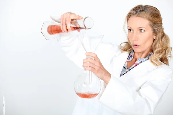 Wetenschapper zorgvuldig mengen chemicaliën — Stockfoto