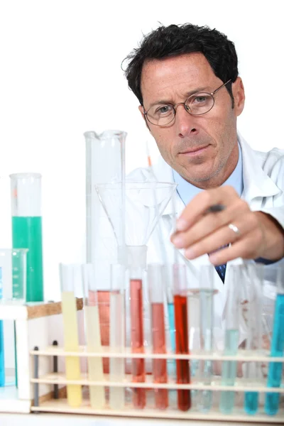 50 anos de idade cientista em um laboratório atrás de tubos de ensaio — Fotografia de Stock