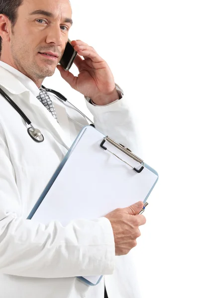 Arzt am Telefon mit Klemmbrett — Stockfoto