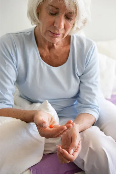 Mulher idosa tomando um comprimido — Fotografia de Stock