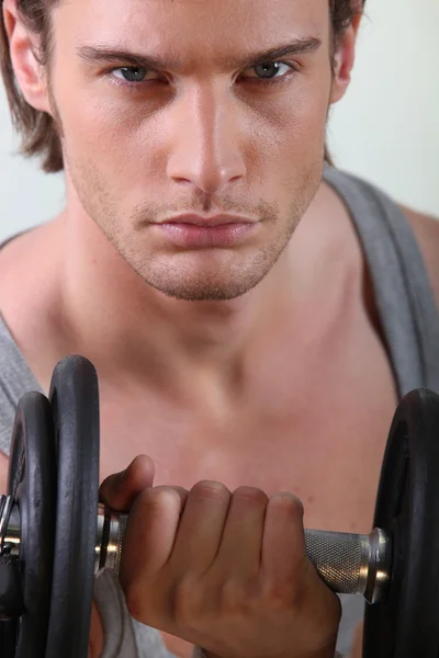 Nahaufnahme eines hübschen jungen Mannes beim Gewichtheben — Stockfoto