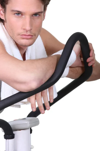 Homem posando com uma máquina de exercício — Fotografia de Stock