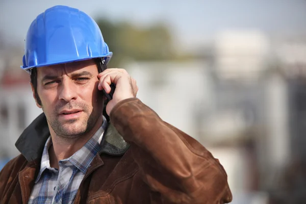 Ein Bauarbeiter telefoniert mit seinem Handy — Stockfoto